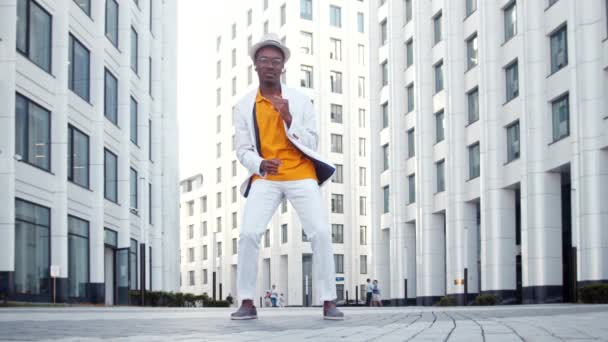 Zwarte man in pak danst op grijze verharde weg in megalopolis — Stockvideo