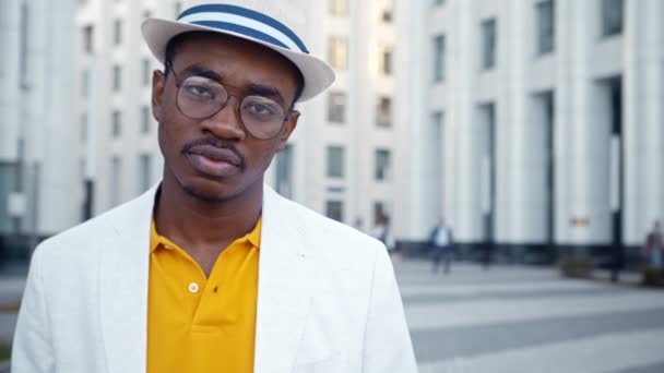 Hombre negro serio en traje clásico y gafas se ve recto — Vídeos de Stock