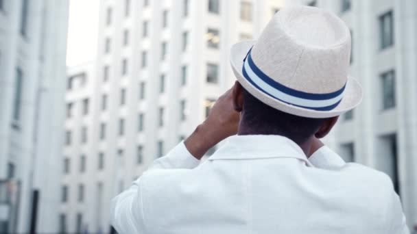 Homem negro de terno filmes panorama de edifícios highrise — Vídeo de Stock