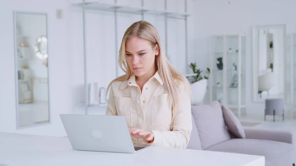 Молода дівчина друкує на ноутбуці в приміщенні Ліцензійні Стокові Зображення