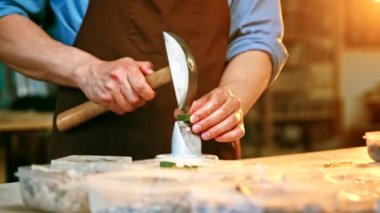 Yaratıcı atölyede elinde çekiçle çalışan bir adam.