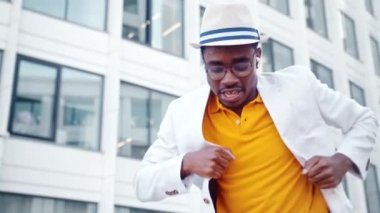 Kulaklıklı ve gözlüklü Afrikalı Amerikalı adam dans ediyor.