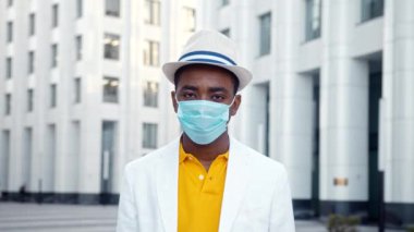 Yüzünde maske olan ciddi bir Afro-Amerikalı.