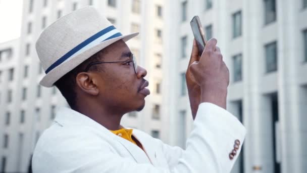 Koncentrerad svart kille i klassiska kostym filmer byggnader — Stockvideo