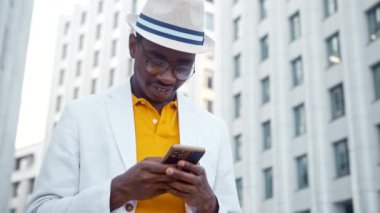 Sarı tişörtlü ve takım elbiseli siyah adam internetten iletişim kuruyor.