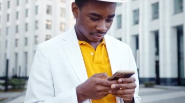 Tişörtlü ve şık takım elbiseli konsantre siyahi adam.