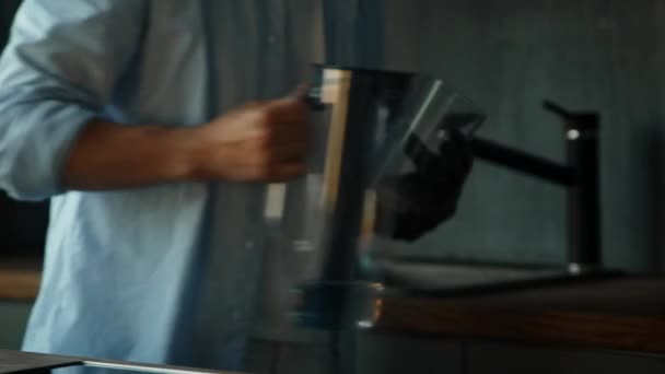 Πρόσωπο με μαύρο τεχνητό χέρι ρίχνει νερό στο γυαλί — Αρχείο Βίντεο