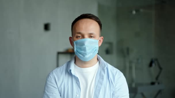 Concentrated guy in blue disposable face mask and t shirt — Stock Video