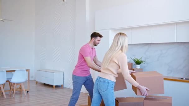 Удивительная влюбленная пара ставит коробки на новом этаже квартиры — стоковое видео