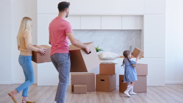 Fantastiska familj föräldrar med liten dotter tar med lådor — Stockvideo