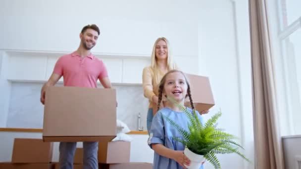 A pequena filha pré-escolar engraçada olha para os pais em apartamento — Vídeo de Stock