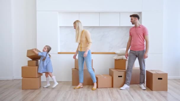 Joven niña preescolar ayuda a los padres a llevar cajas en plano — Vídeo de stock