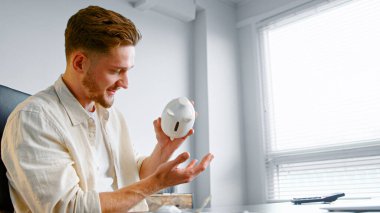 Finans müdürünün elinde beyaz domuz kumbarası var.