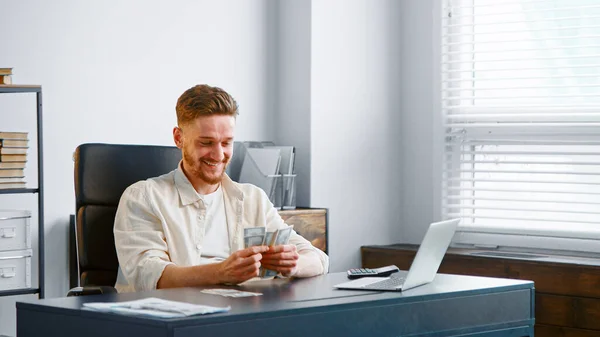 Succesvolle zakenman met baard telt cash geld met een vrolijke glimlach — Stockfoto