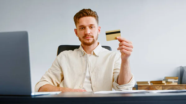 Seriózní muž firemní manažer s plnovousem drží žlutou bankovní kartu — Stock fotografie