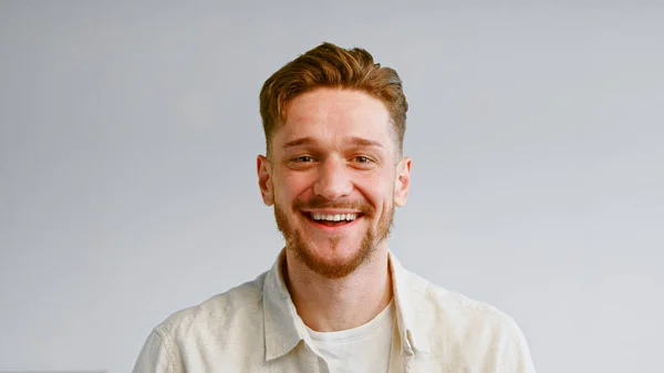 Portretul unui tip cu barbă serioasă în cămașă galbenă care arată drept și apoi zâmbește vesel — Fotografie, imagine de stoc