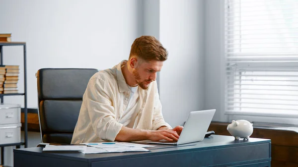 Un homme d'affaires concentré signe un contrat en ligne et lève la main Images De Stock Libres De Droits