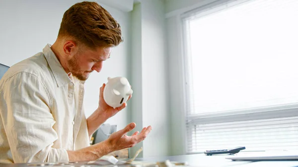 Ung ekonomichef håller vit spargris bank Stockbild