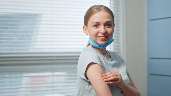 Attractive girl examines injection spot on forearm and looks straight — Stock Photo, Image