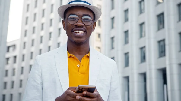 Smiling African American man in glasses and hat looking at camera — Stock Photo, Image
