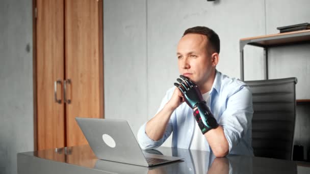 Gehandicapte man programmeur met bio handprothese aan tafel — Stockvideo