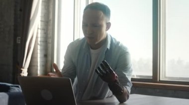 İş görüşmesinde yapay elle konuşan neşeli bir adam.