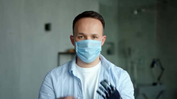 Man cyborg met zwarte bio handprothese neemt blauw masker af — Stockvideo