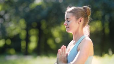 Yoga pozisyonunda meditasyon yapan konsantre sarışın genç bir kadın.