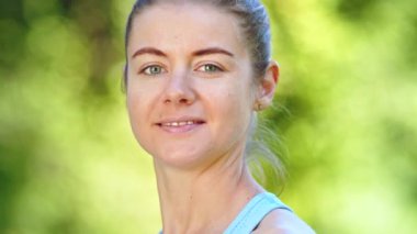 Saçlı çörekli genç bir kadın neşeli bir gülümsemeyle başını çeviriyor.