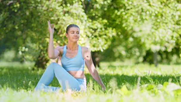 Signora in top blu e leggings si siede in posa relax — Video Stock