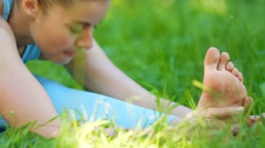 Eşofmanlı genç kadın bacaklarını ve bacaklarını açıyor.