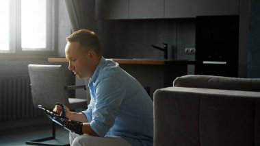 Yoğunlaştırılmış engelli adam cyborg tipleri ve akıllı telefon düğmeleri siyah biyolojik el protezini tutuyor.