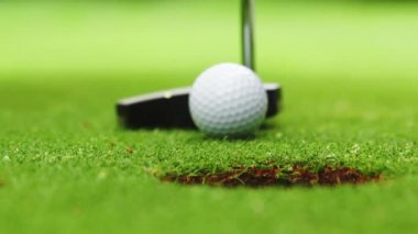 Golfçü topu deliğe atıyor.