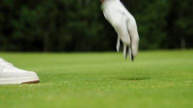 Eldivenli erkek eller delikten bir golf topu alır.