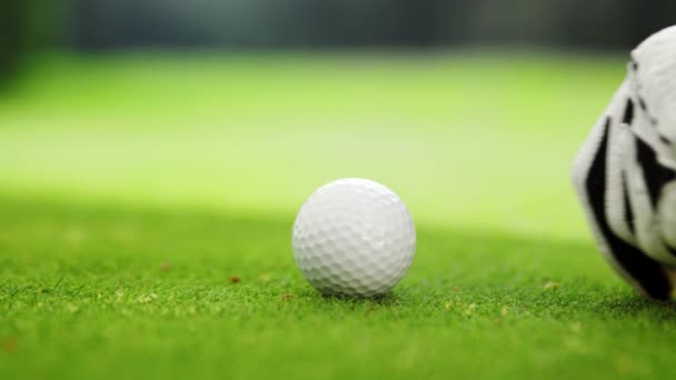 La mano en un guante blanco golpea la pelota en un césped verde — Vídeos de Stock