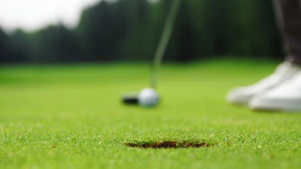 Jugador de golf golpeando una pelota de golf en un agujero — Vídeos de Stock