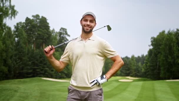 Uśmiechnięty młodzieniec z miotaczem na polu golfowym — Wideo stockowe