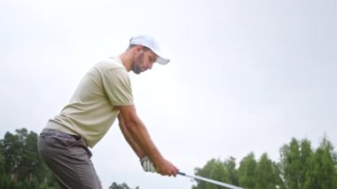 Golf oynayan üniformalı genç bir golfçü.
