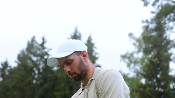 Portret van een jonge golfer voor te bereiden om te raken met een club — Stockvideo