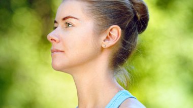 Sarı saçlı genç bir kadın başını çevirir ve neşeli bir gülümsemeyle dümdüz görünür.