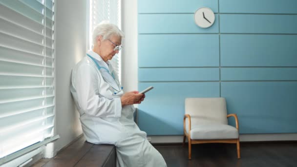 Läkaren konsulterar patienten på videocall sitter på sjukhus — Stockvideo