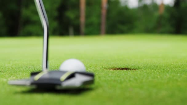 Golfare hamrar bollen i hålet på golfbanan — Stockvideo
