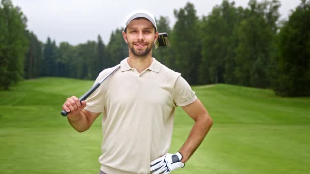 Hombre sonriente con palo de golf mirando a la cámara — Vídeos de Stock