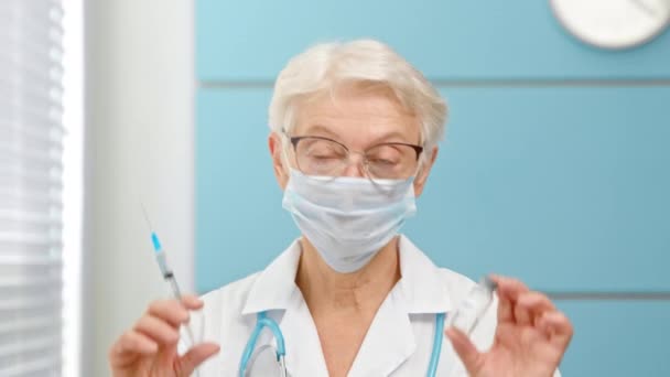 Doctor holds vial and syringe standing in hospital office — Stock Video