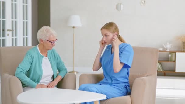 Trabajador médico escucha corazón de mujer anciana con estetoscopio — Vídeos de Stock