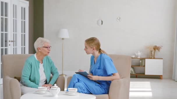 Yaşlı kadın uzun süreli bakım evinde genç doktorla konuşuyor. — Stok video
