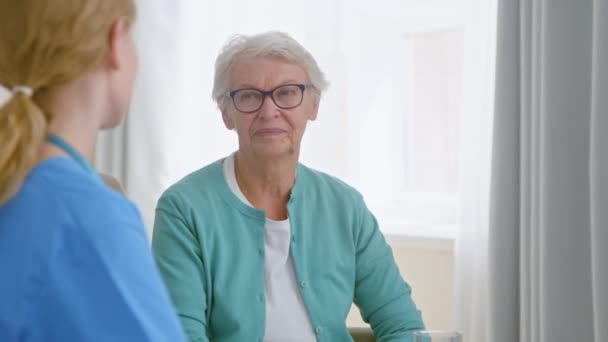 Opiekun daje wodzie komunikację z dojrzałym pacjentem — Wideo stockowe