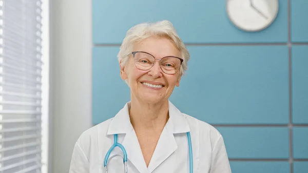 Γκρίζα μαλλιά ηλικιωμένη γιατρός γυναίκα με στηθοσκόπιο — Φωτογραφία Αρχείου