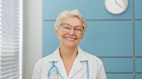 Medico anziano dai capelli grigi con stetoscopio — Foto Stock