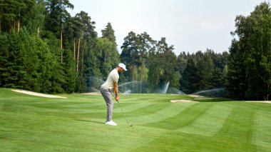 Dışarıda golf oynayan üniformalı genç bir golfçü.
